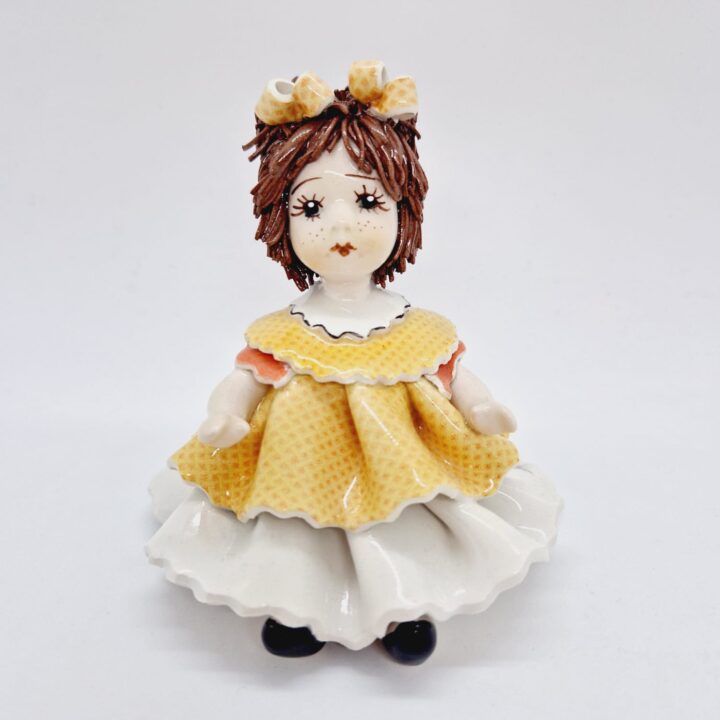 Sitting doll with orange dress